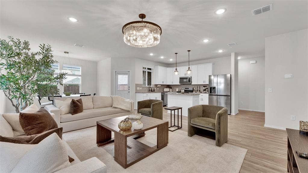 707 Indigo Road, Princeton, TX 75407 Open-concept living space featuring a contemporary chandelier, recessed lighting, and wood-finish flooring