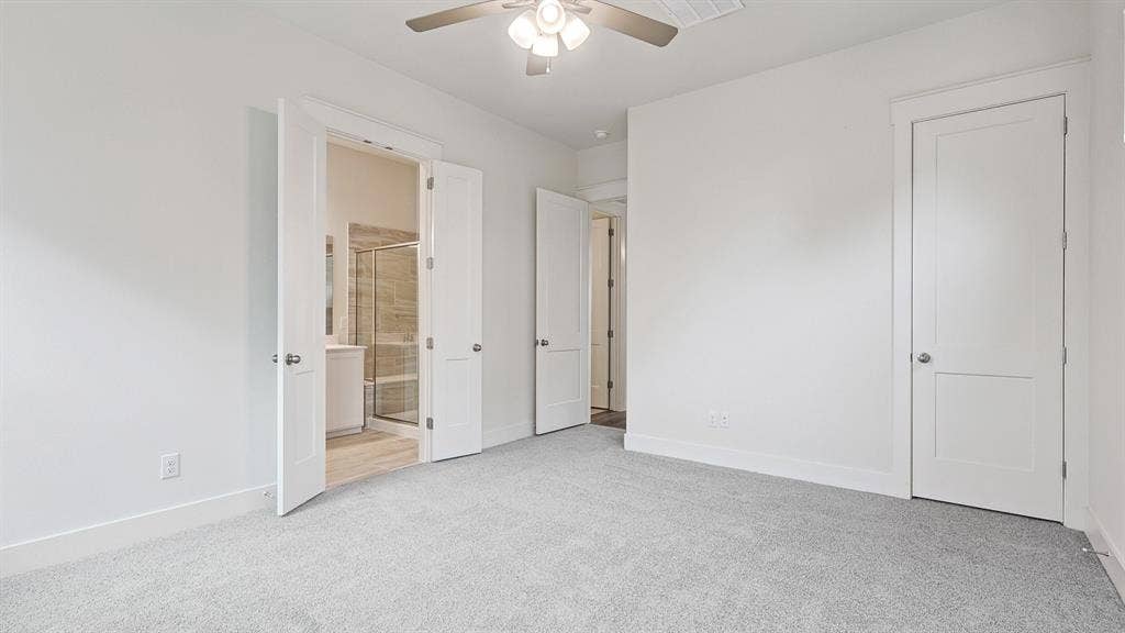 Carpeted room with a ceiling fan, white walls, and white trim
