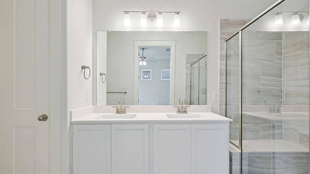 White shaker-style dual vanity with undermount sinks and a light-toned countertop