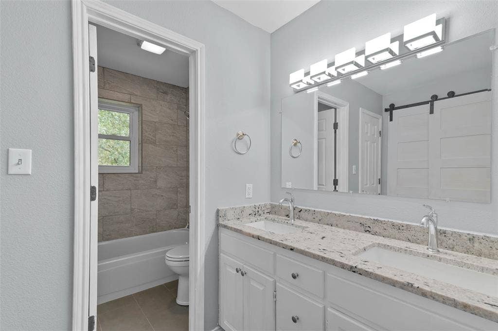 Primary bathroom features granite countertops, dual sinks and two closets.