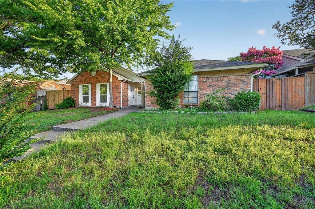 428 Dollins Street, Cedar Hill, TX 75104 Brick exterior residence featuring white window shutters, a front entry walkway, and mature trees providing natural shading