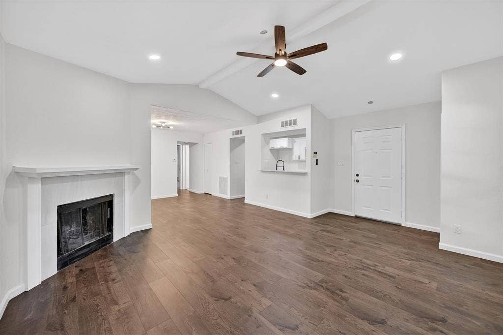 428 Dollins Street, Cedar Hill, TX 75104 Open-concept living area featuring wood-finish flooring, a white mantel fireplace, a ceiling fan with light fixture, recessed lighting, and a kitchen pass-through window with a breakfast bar
