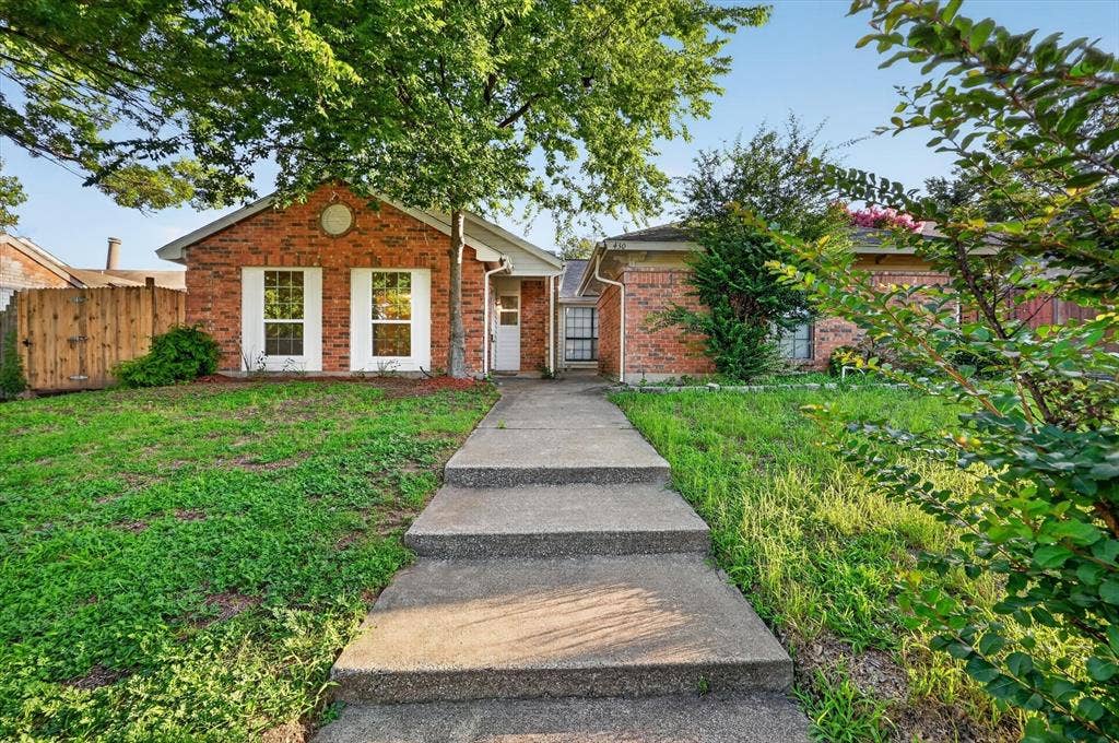 428 Dollins Street, Cedar Hill, TX 75104 Brick facade residence featuring a concrete walkway, established front lawn, mature trees, and white window shutters