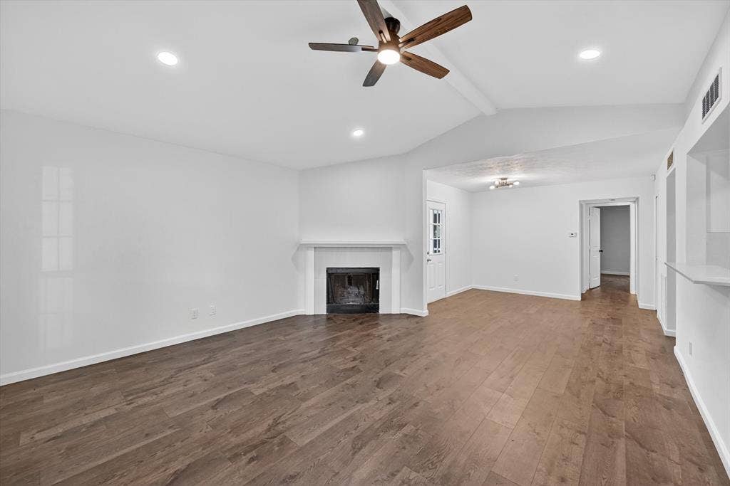 428 Dollins Street, Cedar Hill, TX 75104 Spacious living area featuring wood-finish flooring, a white mantel fireplace, recessed lighting, and a ceiling fan with wood-tone blades
