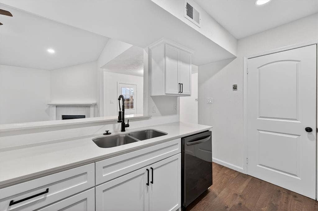 428 Dollins Street, Cedar Hill, TX 75104 Kitchen featuring white cabinetry, a double basin stainless steel sink with a matte black faucet, light-toned countertops, and wood-finish flooring