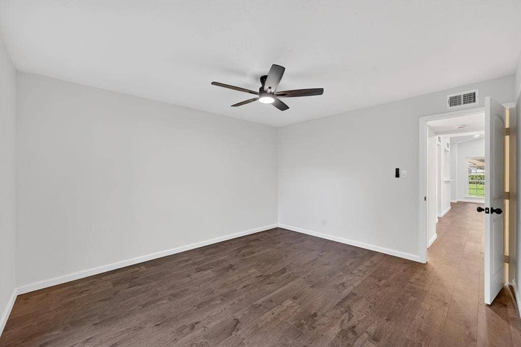 428 Dollins Street, Cedar Hill, TX 75104 Spacious room featuring wood-finish flooring, light neutral wall tones, and a modern ceiling fan with integrated lighting
