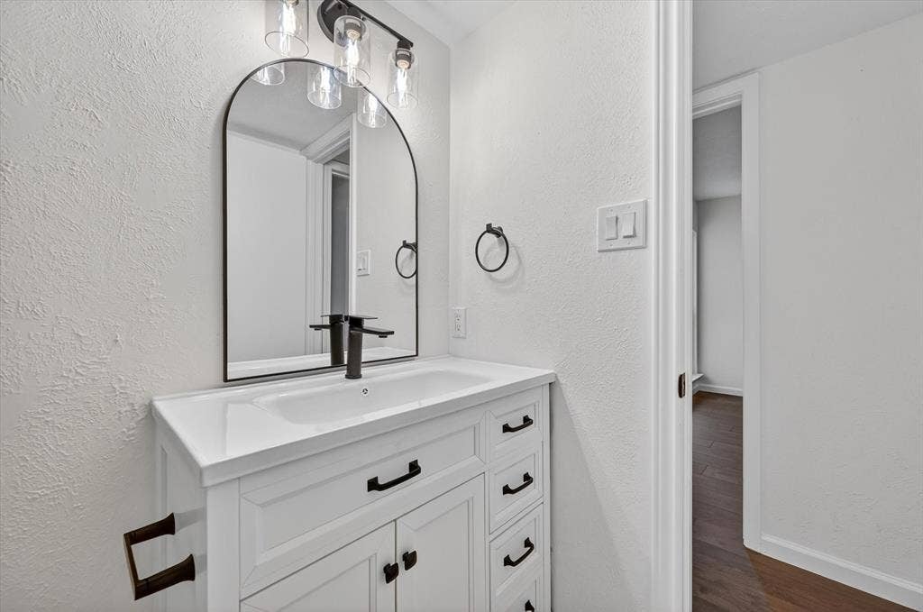 428 Dollins Street, Cedar Hill, TX 75104 Bathroom vanity featuring a white cabinet with black hardware, an integrated sink, and a black-finish faucet