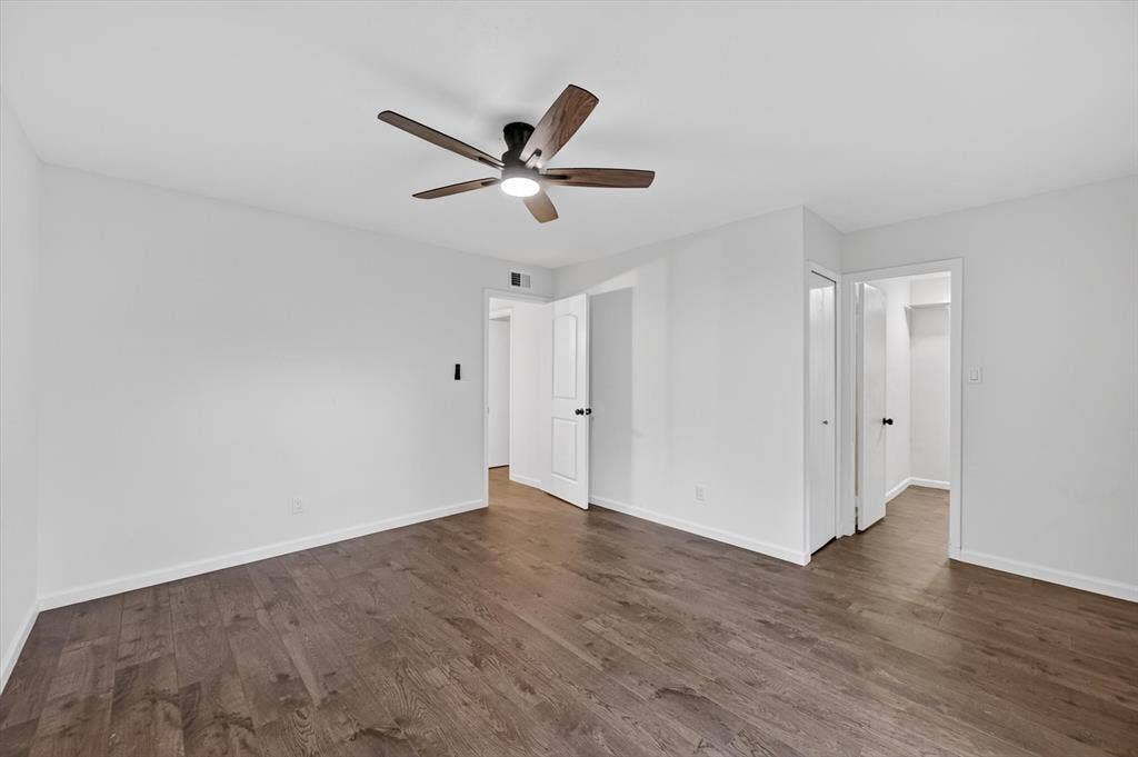 428 Dollins Street, Cedar Hill, TX 75104 Spacious room featuring wood-finish flooring, crisp white walls, a ceiling fan with integrated lighting, and multiple doorways
