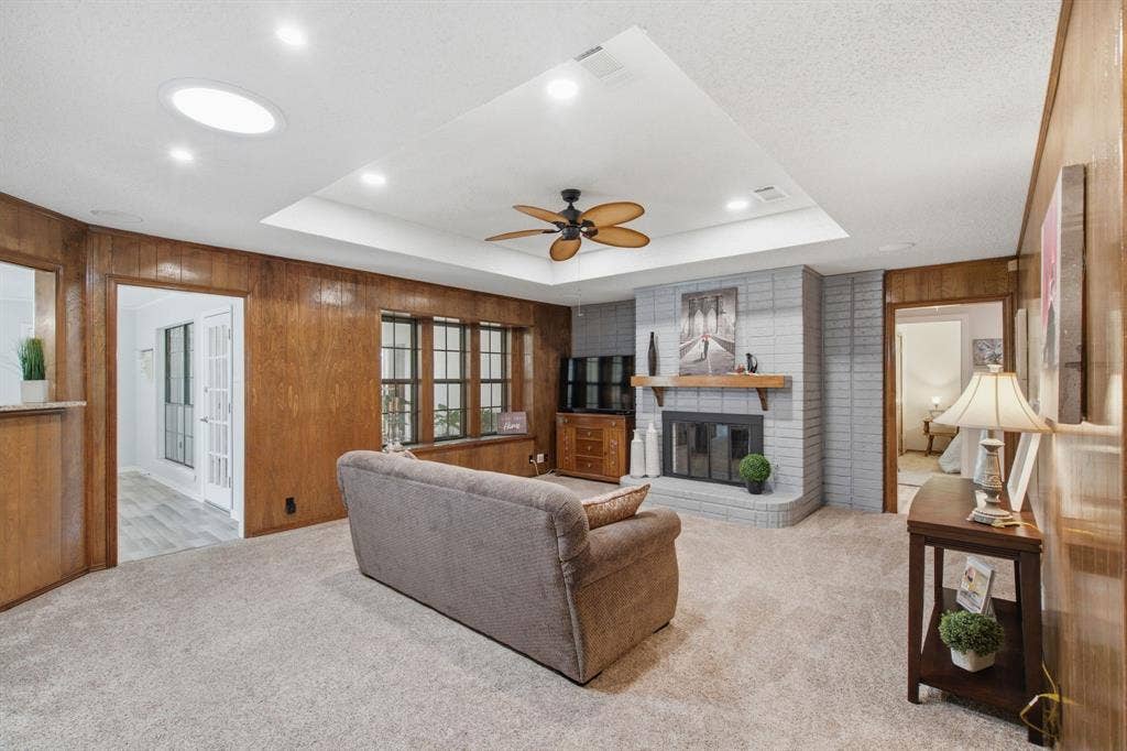 521 W Louella Drive, Hurst, TX 76054 View from the entry shows a spacious and cozy living room with a entry on the left into the secondary living room, leads to the bedrooms at the right and sees into the enclosed sunroom through the windows.