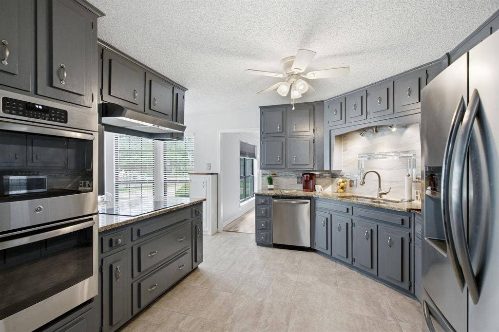 521 W Louella Drive, Hurst, TX 76054 Tons of storage in this kitchen including a pantry in the eat in kitchen area. Double oven, electric cooktop, double sink, and decorative lighting over the sink.