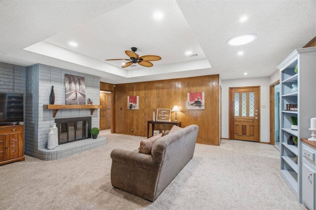 521 W Louella Drive, Hurst, TX 76054 Spacious main living room with painted fireplace, paneling and built in bookshelf. Canned lights , ceiling fan, and a solar skylight offers additional light even when other lights are off.