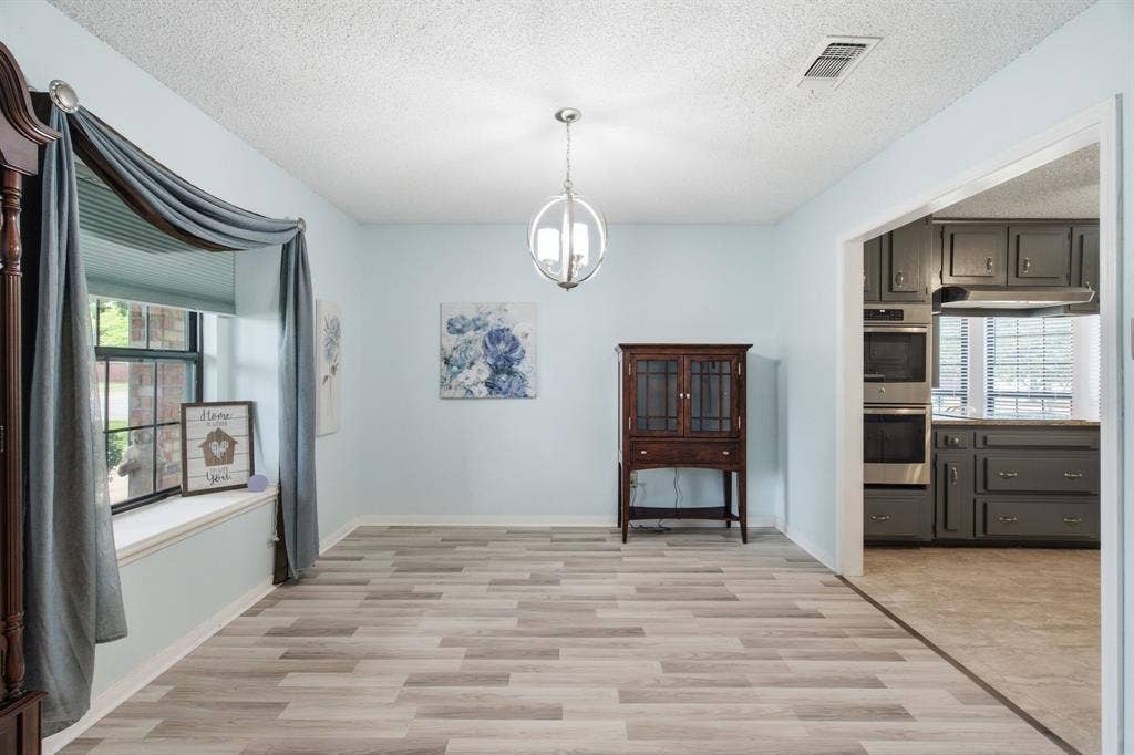 521 W Louella Drive, Hurst, TX 76054 Dining room is to the left as you walk in and leads into the kitchen. Love the window seat and wider opening into the kitchen.