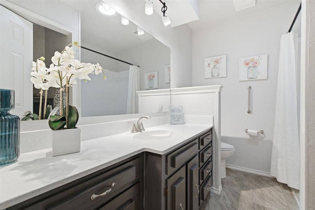 521 W Louella Drive, Hurst, TX 76054 Secondary bathroom with extra storage shelves behind the door.