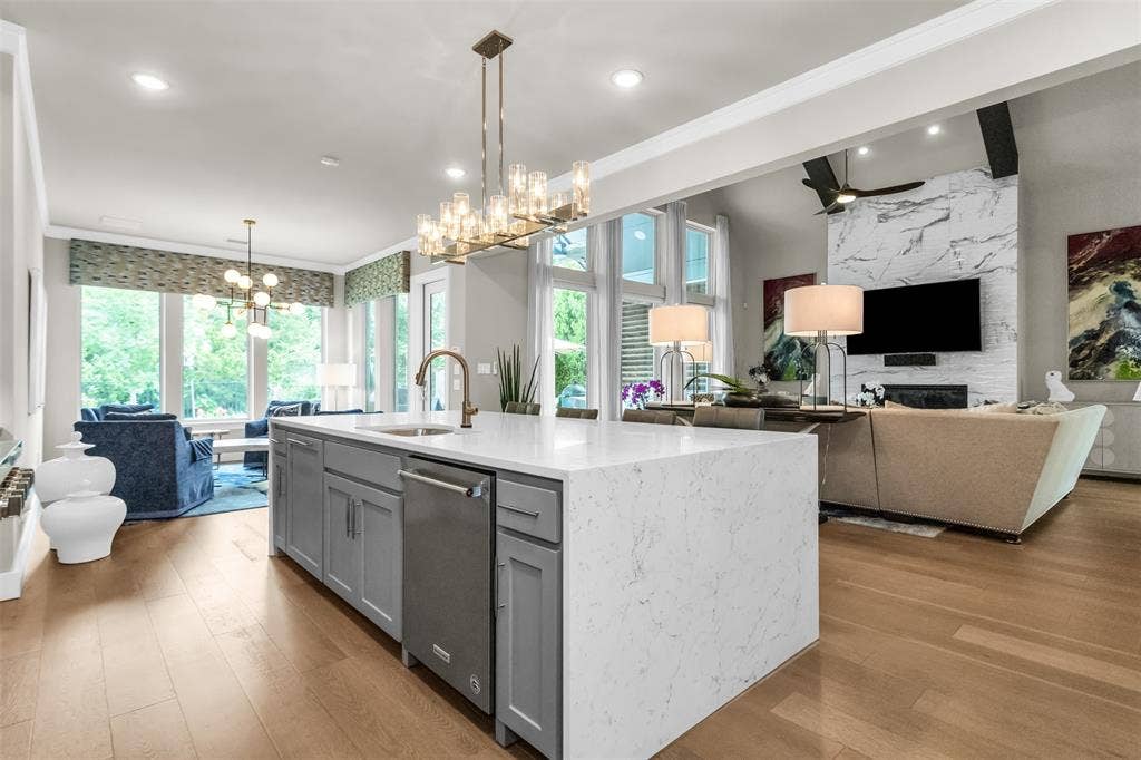 8138 Edgefield Court, Frisco, TX 75035 Expansive kitchen island with a waterfall countertop, integrated sink, and stainless steel dishwasher