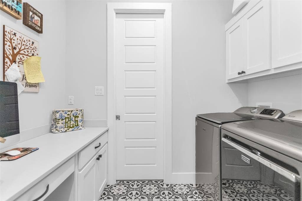 8138 Edgefield Court, Frisco, TX 75035 Laundry area featuring patterned floor tile, white shaker-style cabinetry, a built-in countertop with an integrated desk space, and a five-panel interior door