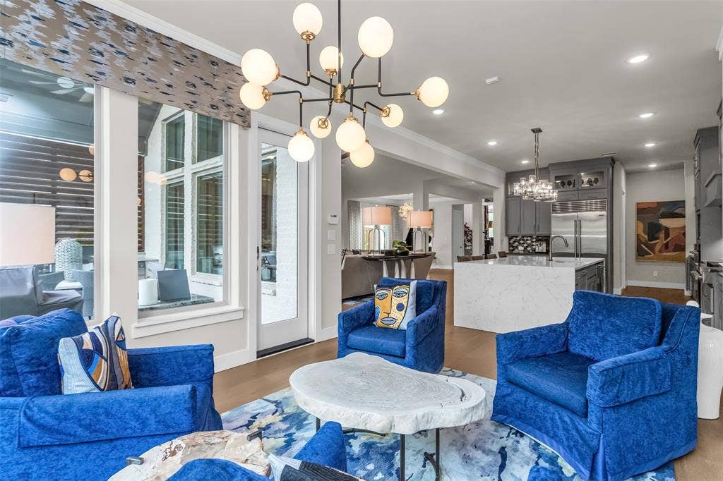 8138 Edgefield Court, Frisco, TX 75035 Open-concept living space with wood-finish flooring, a contemporary chandelier, and recessed lighting