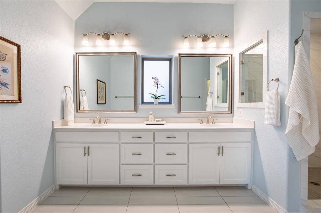 7405 Collin Mckinney Parkway, McKinney, TX 75070 Double vanity featuring white cabinetry and quartz countertops