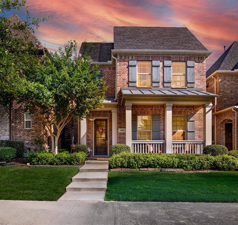 7405 Collin Mckinney Parkway, McKinney, TX 75070 Brick home featuring a covered front porch with white railing, front yard landscaping, concrete pathway, and decorative window shutters