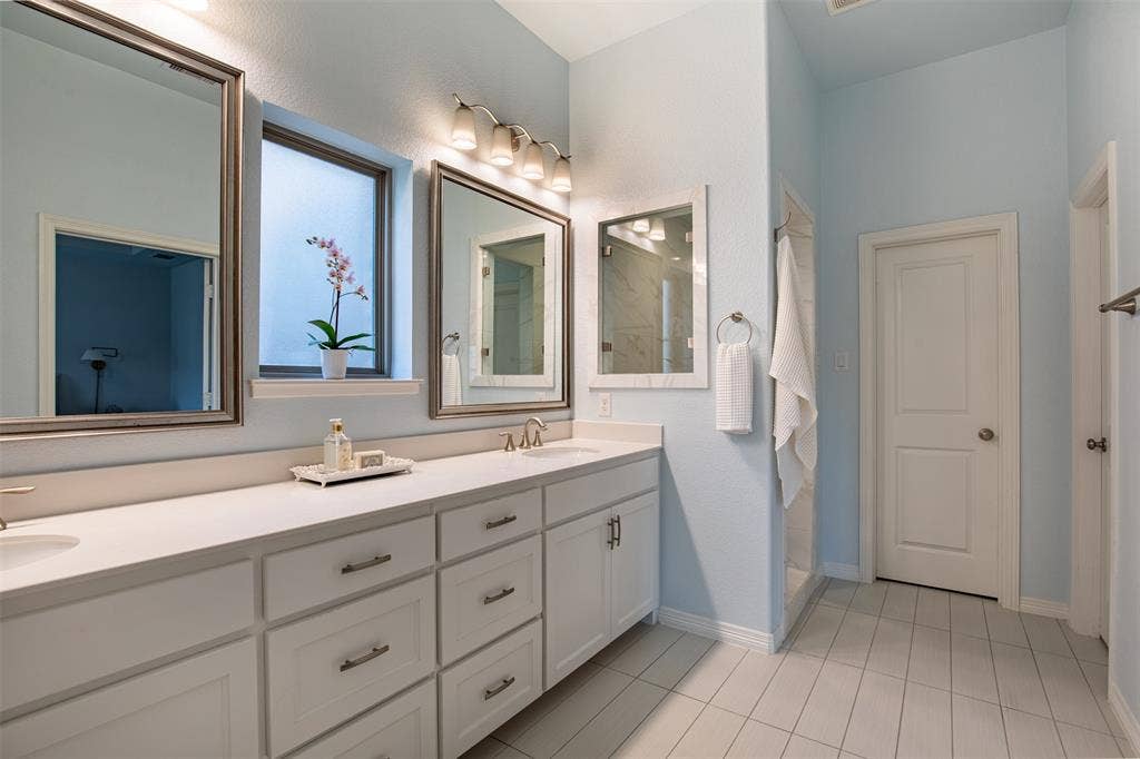 7405 Collin Mckinney Parkway, McKinney, TX 75070 Walk in Shower. Double vanity featuring white cabinetry and quartz countertops.