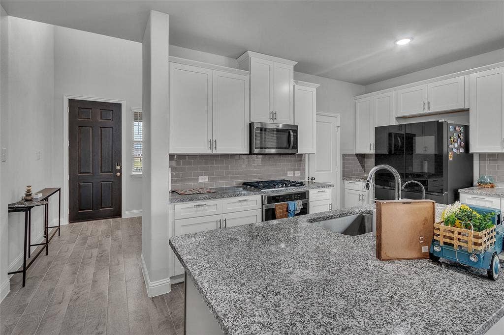 3708 Jan Camille Court, Celina, TX 75009 Kitchen featuring appliances with stainless steel finishes, sink, white cabinets, and light hardwood / wood-style floors