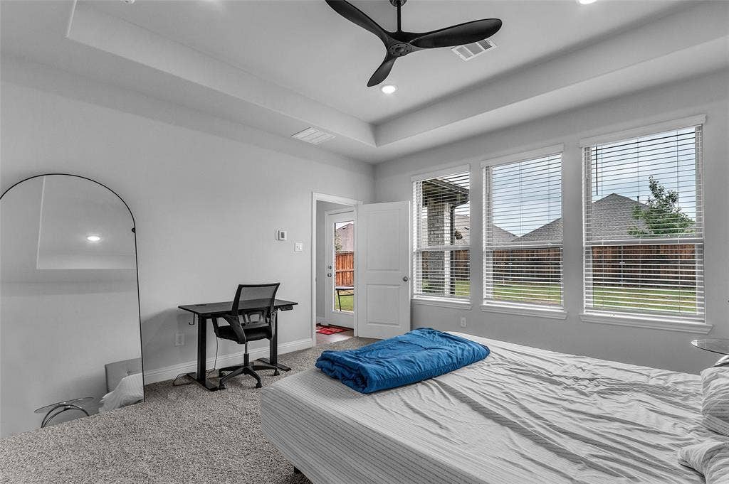 3708 Jan Camille Court, Celina, TX 75009 Bedroom with multiple windows, a tray ceiling, and ceiling fan