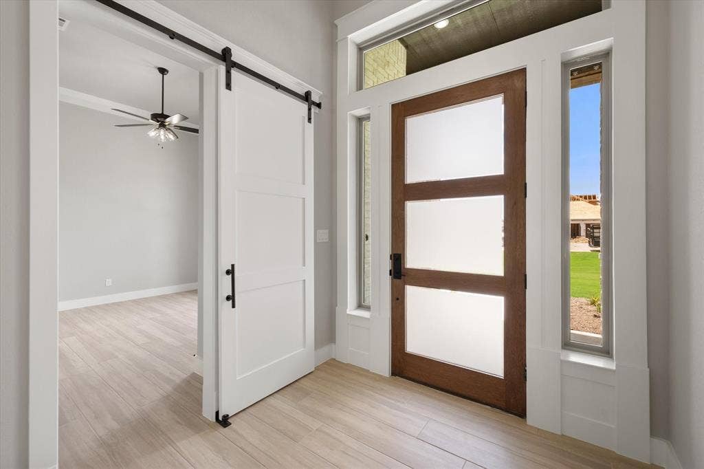 6610 Waggoner Way, Midlothian, TX 76065 Modern wood-finish front door with frosted glass panels, flanked by sidelight windows and a transom window