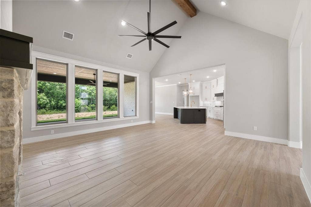 6610 Waggoner Way, Midlothian, TX 76065 Spacious living area featuring vaulted ceilings with exposed wood beam, recessed lighting, and a contemporary ceiling fan