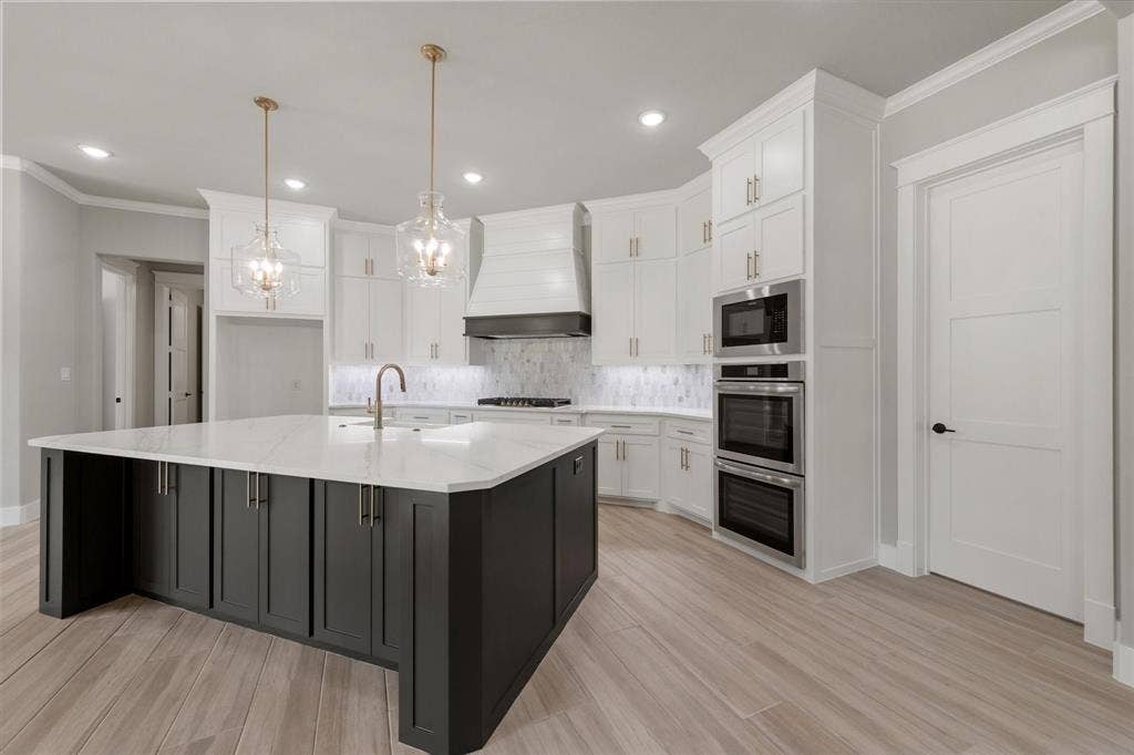 6610 Waggoner Way, Midlothian, TX 76065 Spacious kitchen featuring a large central island with dark cabinetry and a light countertop