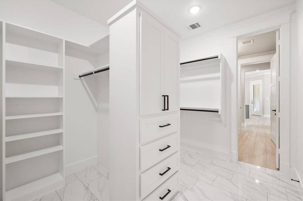 6610 Waggoner Way, Midlothian, TX 76065 Custom white built-in cabinetry with black hardware, shelving, and hanging rods