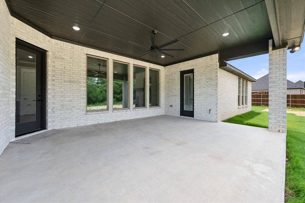 6610 Waggoner Way, Midlothian, TX 76065 Expansive covered patio featuring a concrete surface, white brick exterior, black ceiling with recessed lighting, and a ceiling fan