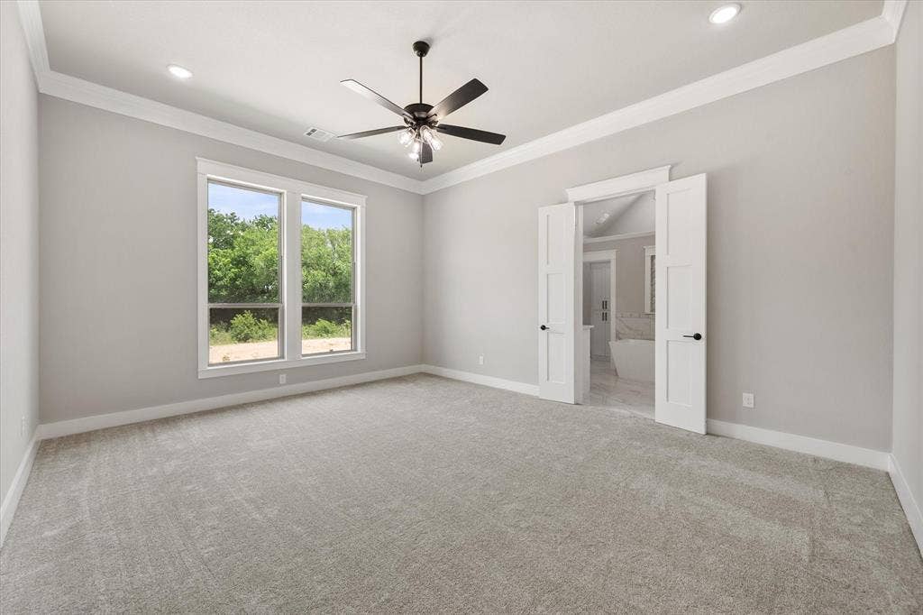 6610 Waggoner Way, Midlothian, TX 76065 Spacious room featuring light gray carpet, multiple windows, a ceiling fan, recessed lighting, and crown molding