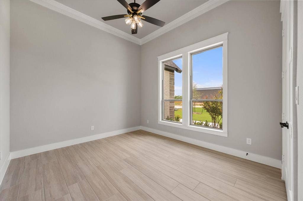 6610 Waggoner Way, Midlothian, TX 76065 Room featuring wood-finish flooring, two large windows, a ceiling fan with integrated lighting, crown molding, and white baseboards
