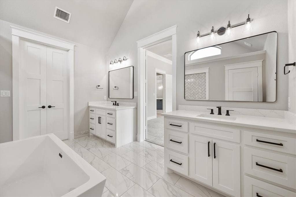 6610 Waggoner Way, Midlothian, TX 76065 Dual vanities with white cabinetry, quartz countertops, and matte black hardware