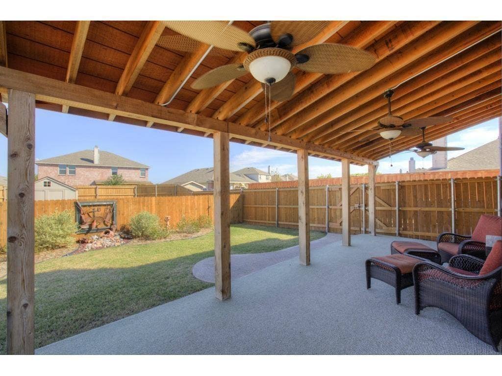 2912 Lake Terrace Drive, Wylie, TX 75098 Expansive covered patio featuring an exposed wood beam ceiling and multiple ceiling fans