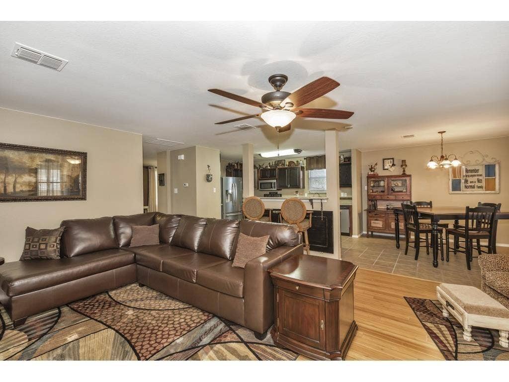 2912 Lake Terrace Drive, Wylie, TX 75098 Spacious living area featuring wood-finish flooring, a ceiling fan with integrated lighting, and neutral wall tones