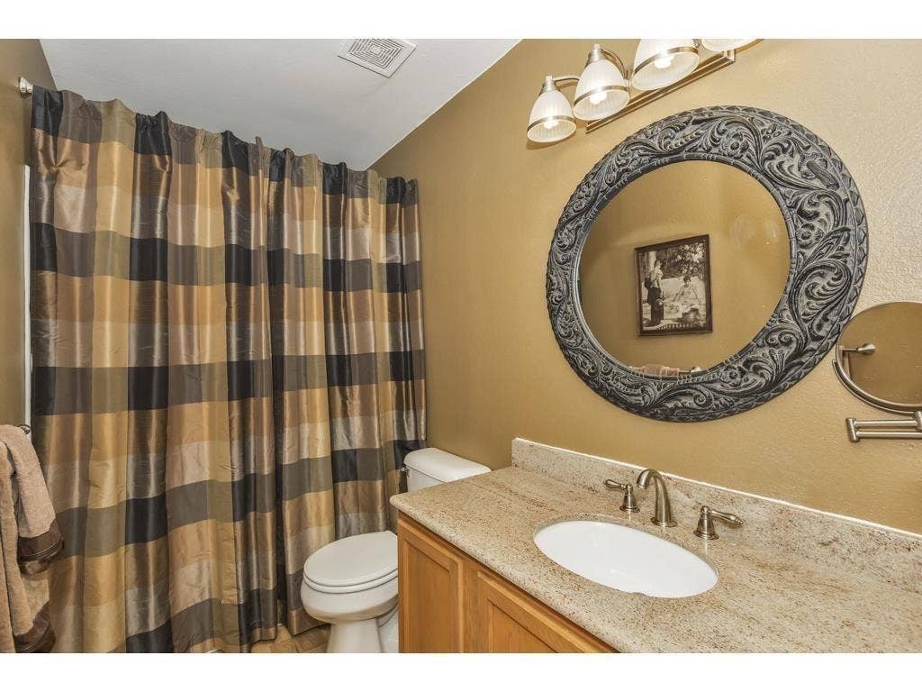 2912 Lake Terrace Drive, Wylie, TX 75098 Bathroom featuring a light-toned vanity with an undermount sink, granite countertop, and brushed nickel faucet