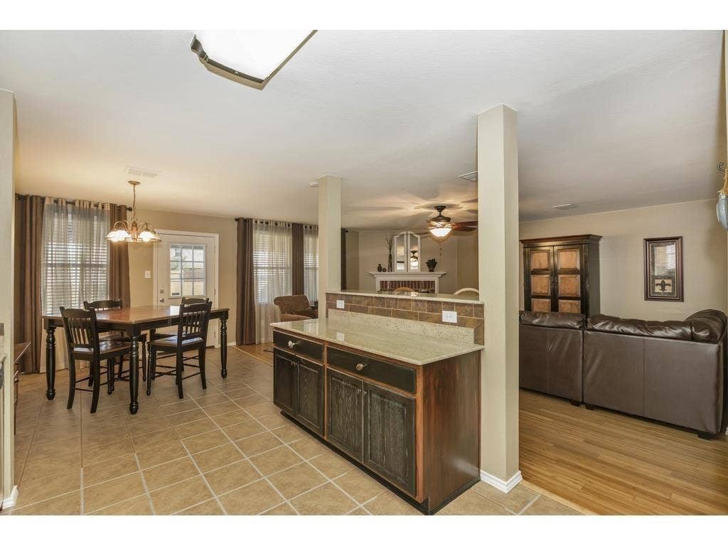 2912 Lake Terrace Drive, Wylie, TX 75098 Open-concept dining area featuring tile flooring, a multi-light chandelier, and a white paneled door with glass inserts