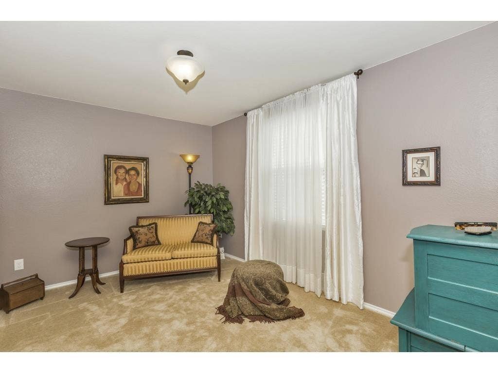 2912 Lake Terrace Drive, Wylie, TX 75098 Spacious room featuring neutral paint tones, light-colored carpeting, a large window with white drapes, and a semi-flush mount ceiling light fixture