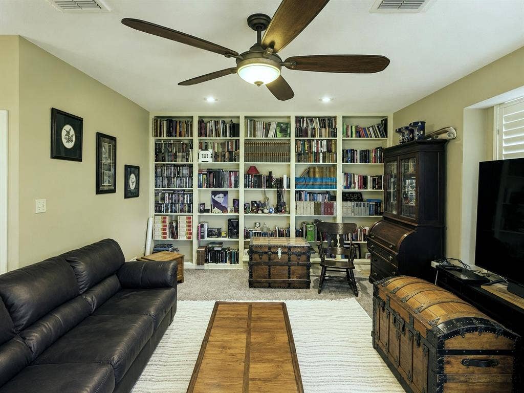 1221 Big Bend Drive, McKinney, TX 75069 The den has plantation covered windows on two walls, one even faces the backyard and floods this end of the house with natural light, Esau wall of built-in shelving and a stately brick hard woodburning fireplace.