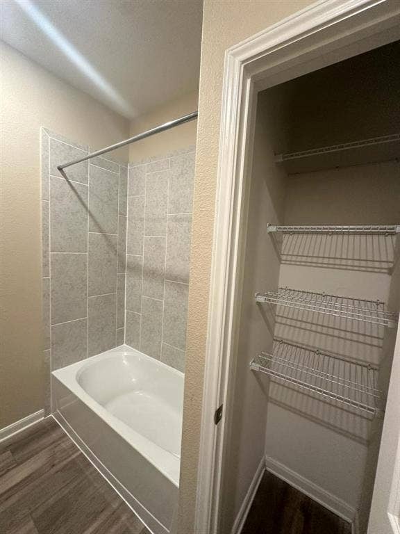1707 Cotton Blossom Lane, Princeton, TX 75407 Bathroom featuring a white bathtub with light gray rectangular tile surround and a chrome shower rod