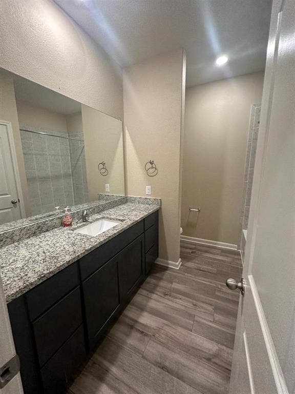 1707 Cotton Blossom Lane, Princeton, TX 75407 Spacious bathroom featuring a long vanity with a light granite countertop, dark cabinetry, and a large mirror