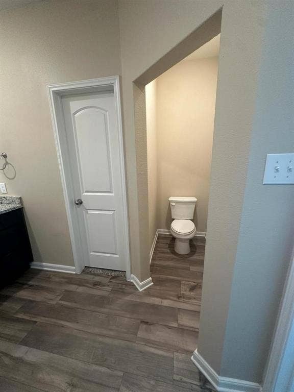 1707 Cotton Blossom Lane, Princeton, TX 75407 Dedicated water closet featuring wood-finish flooring, neutral wall tones, and crisp white baseboards