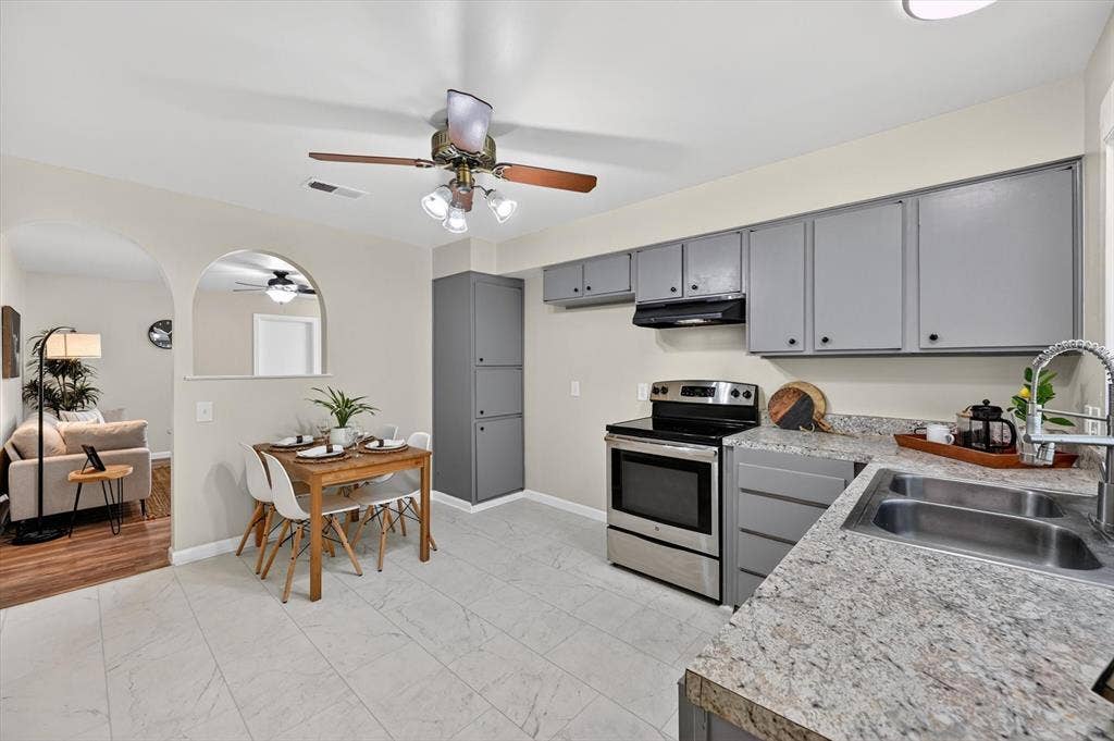 1012 Plover Lane, Arlington, TX 76015 Kitchen featuring stainless steel appliances, dual basin sink, light-toned countertops, and grey cabinetry
