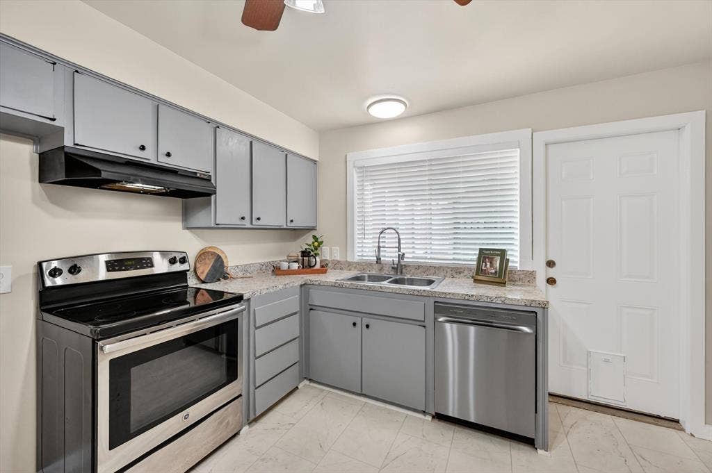 1012 Plover Lane, Arlington, TX 76015 Kitchen featuring gray cabinetry, light-toned countertops, and a white paneled door