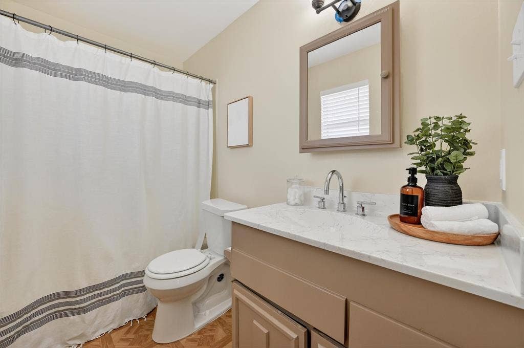 1012 Plover Lane, Arlington, TX 76015 Full bathroom featuring a single vanity with a solid surface countertop, chrome faucet, and a wall-mounted medicine cabinet