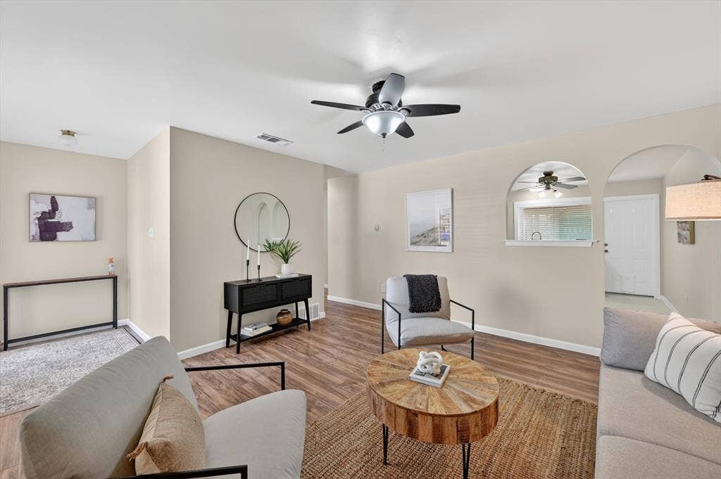 1012 Plover Lane, Arlington, TX 76015 Spacious living area featuring wood-finish flooring, a ceiling fan with integrated lighting, and neutral wall tones