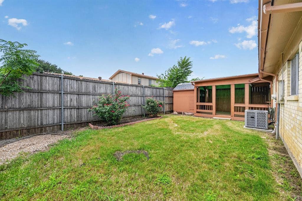 1012 Plover Lane, Arlington, TX 76015 Spacious backyard featuring a covered patio, a detached storage shed, and a privacy fence