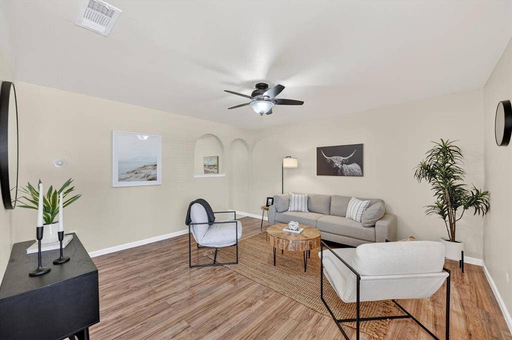 1012 Plover Lane, Arlington, TX 76015 Spacious living area featuring wood-finish flooring, neutral wall tones, and recessed arched wall niches