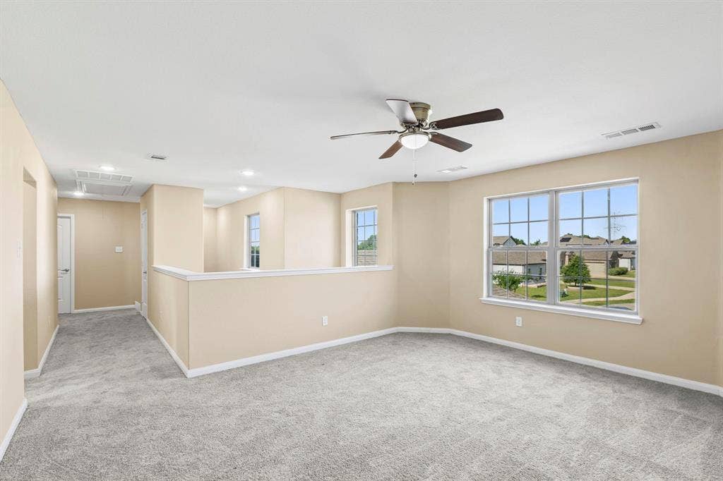 1516 Kinglet Street, DeSoto, TX 75115 Spacious loft area featuring light gray carpet flooring and neutral wall tones