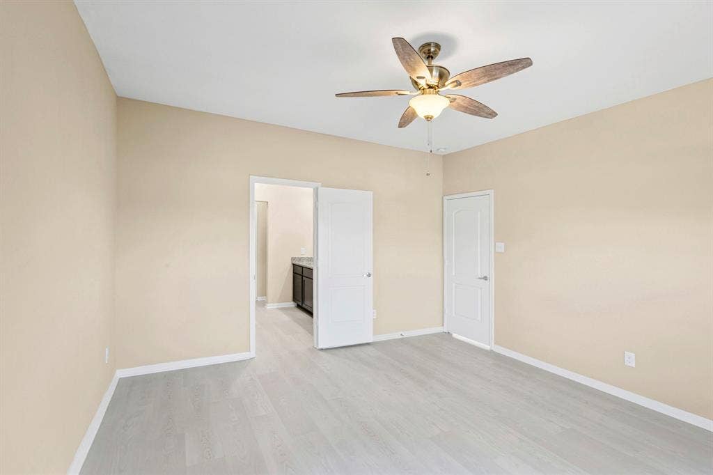1516 Kinglet Street, DeSoto, TX 75115 Spacious room featuring vaulted ceilings, light wood-finish flooring, and neutral wall tones
